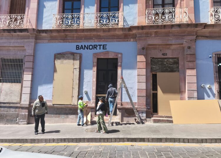 Comerciantes protegen fachadas de sus negocios, ante posibles agresiones de la marcha del 8M